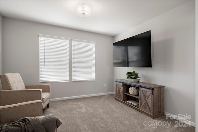 living area with a healthy amount of sunlight and light colored carpet