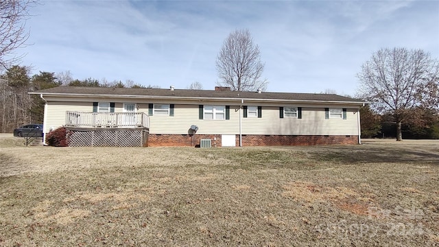 view of front facade featuring central air condition unit, a wooden deck, and a front lawn