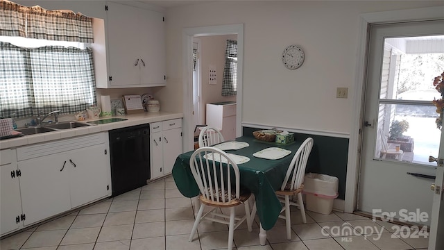 kitchen with white cabinets, black dishwasher, light tile patterned floors, and sink