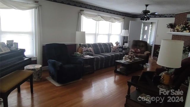 living room with wood-type flooring and ceiling fan