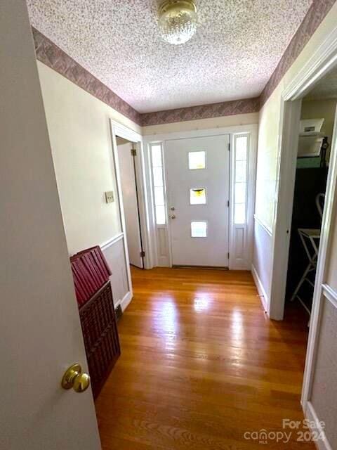 entrance foyer featuring a textured ceiling and light hardwood / wood-style floors