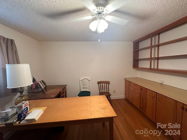 office space with dark wood-type flooring, a textured ceiling, and ceiling fan