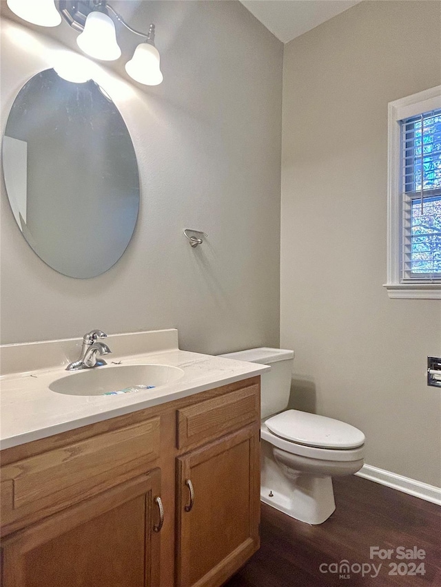 bathroom featuring toilet, vanity, and hardwood / wood-style flooring