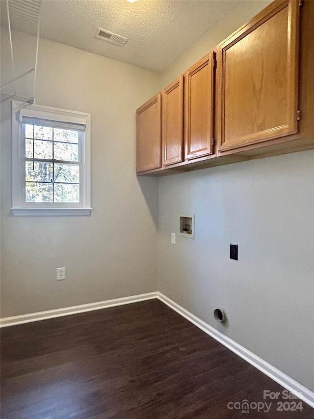 laundry area with cabinets, hookup for a washing machine, a textured ceiling, and dark hardwood / wood-style floors