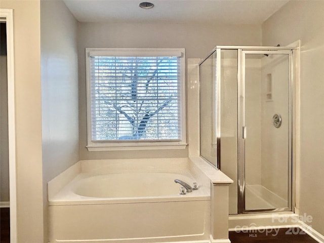 bathroom featuring shower with separate bathtub