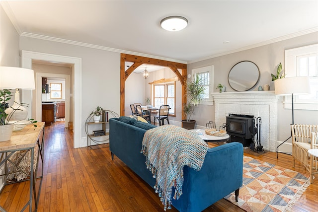 living room featuring dark hardwood / wood-style flooring, a wood stove, and ornamental molding