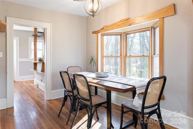 dining space featuring dark hardwood / wood-style flooring and an inviting chandelier