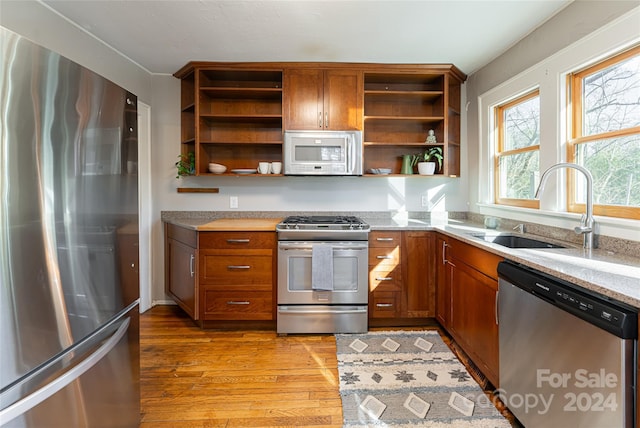 kitchen with sink, stainless steel appliances, and light wood-type flooring