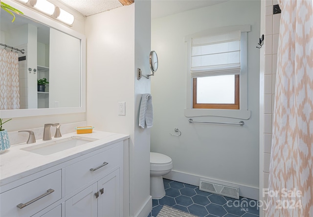 bathroom featuring tile patterned floors, vanity, curtained shower, and toilet