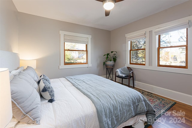 bedroom with hardwood / wood-style floors, ceiling fan, and multiple windows