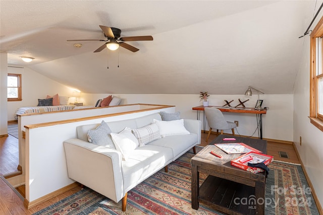 living room featuring ceiling fan, wood-type flooring, a textured ceiling, and vaulted ceiling