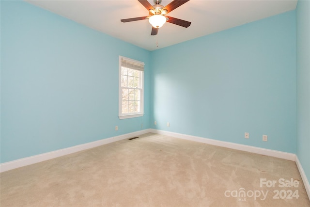 spare room featuring ceiling fan and light colored carpet