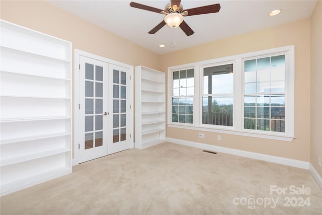 carpeted empty room featuring ceiling fan and french doors