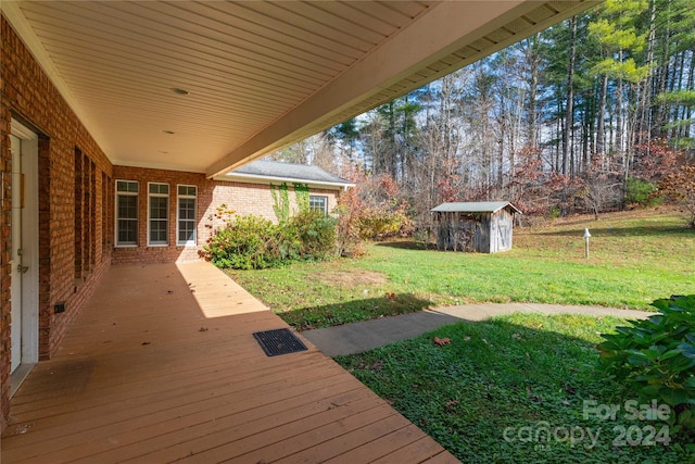 deck featuring a storage unit and a yard