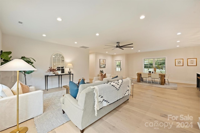 living room featuring light hardwood / wood-style flooring and ceiling fan