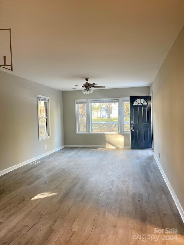 unfurnished living room with ceiling fan and wood-type flooring