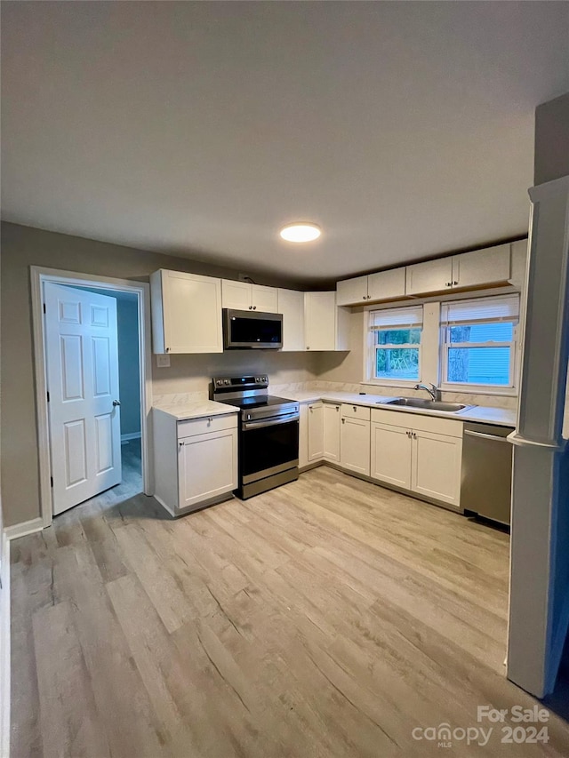 kitchen featuring sink, appliances with stainless steel finishes, and white cabinetry