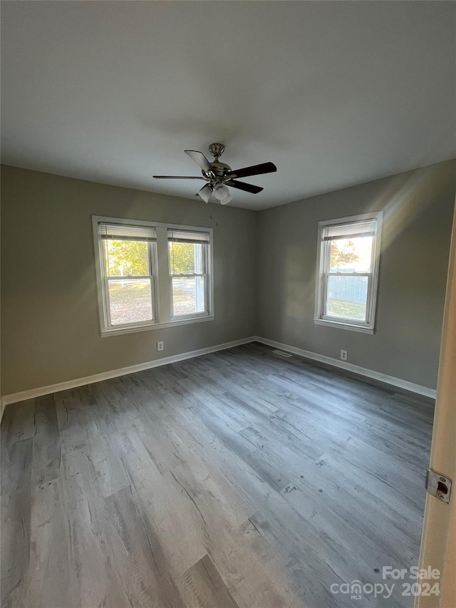 unfurnished room with light hardwood / wood-style floors, ceiling fan, and a wealth of natural light