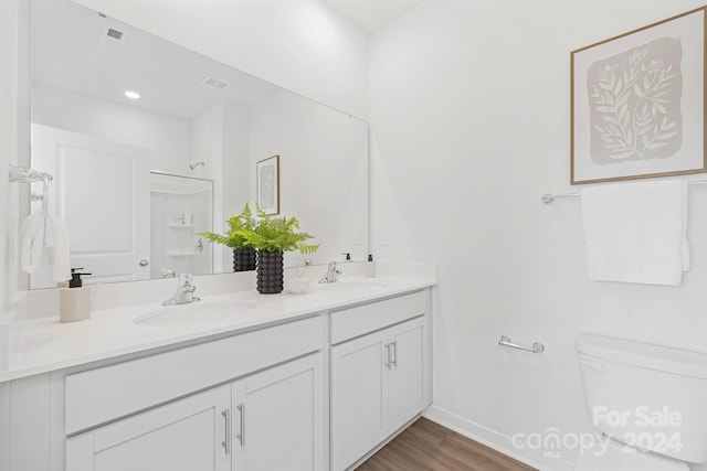 bathroom featuring vanity, hardwood / wood-style flooring, toilet, and walk in shower