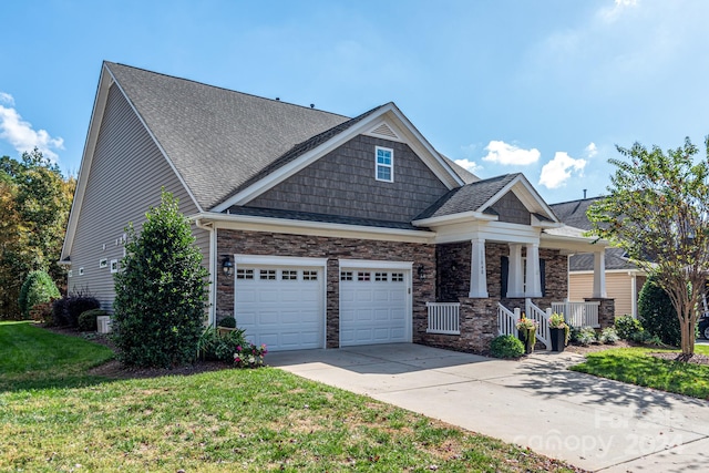 craftsman house featuring a front yard, a garage, and covered porch