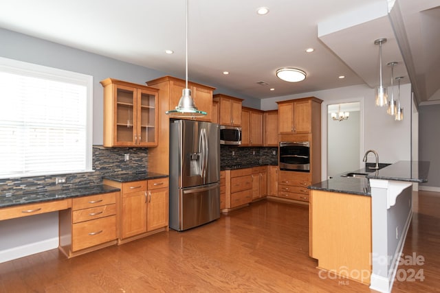 kitchen featuring sink, hanging light fixtures, stainless steel appliances, and light hardwood / wood-style floors