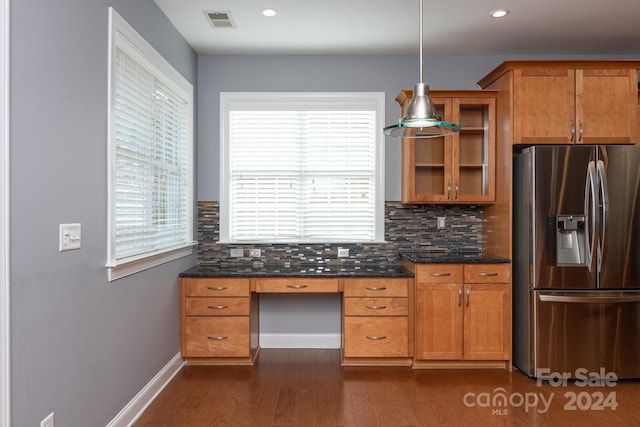 kitchen featuring decorative backsplash, dark wood-type flooring, stainless steel refrigerator with ice dispenser, dark stone countertops, and pendant lighting