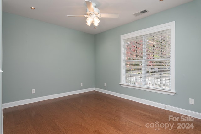 unfurnished room featuring dark wood-type flooring and ceiling fan