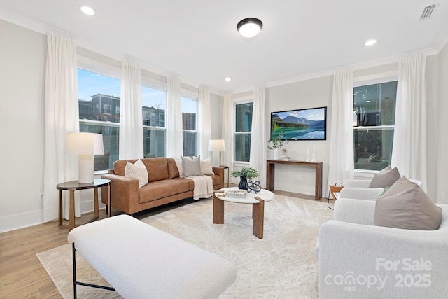 living room with ornamental molding and light hardwood / wood-style floors