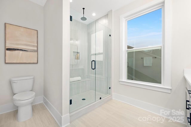 bathroom featuring toilet and a shower with shower door