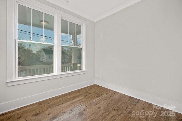 empty room featuring crown molding and wood-type flooring