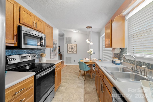 kitchen featuring stainless steel appliances, sink, pendant lighting, and decorative backsplash