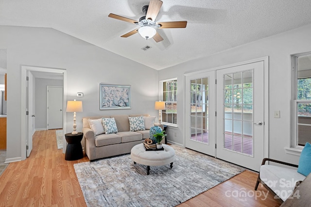 living room featuring light wood-type flooring, plenty of natural light, ceiling fan, and vaulted ceiling