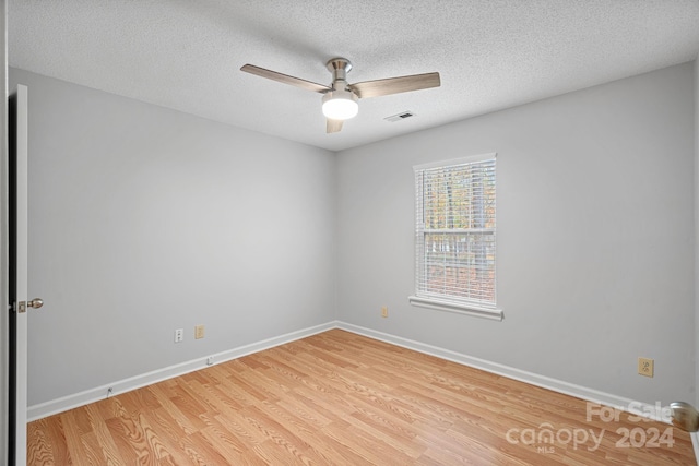 empty room with light hardwood / wood-style flooring, a textured ceiling, and ceiling fan