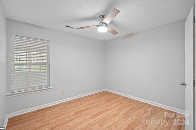 spare room featuring ceiling fan, a textured ceiling, and light hardwood / wood-style flooring