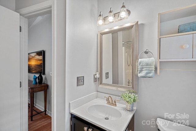 bathroom with hardwood / wood-style floors, vanity, and toilet