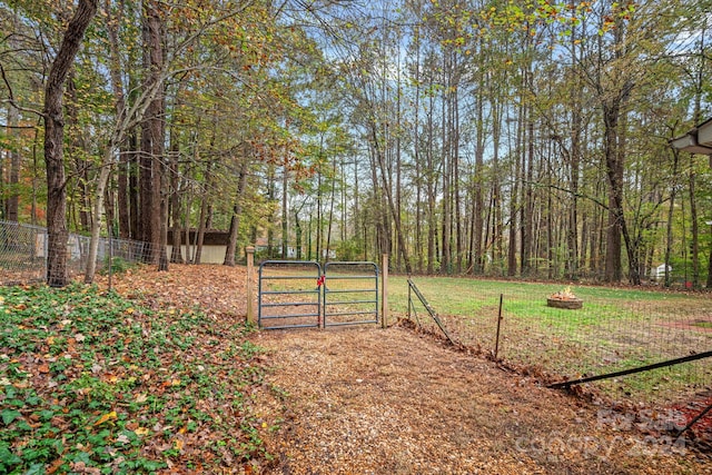 view of gate with a lawn