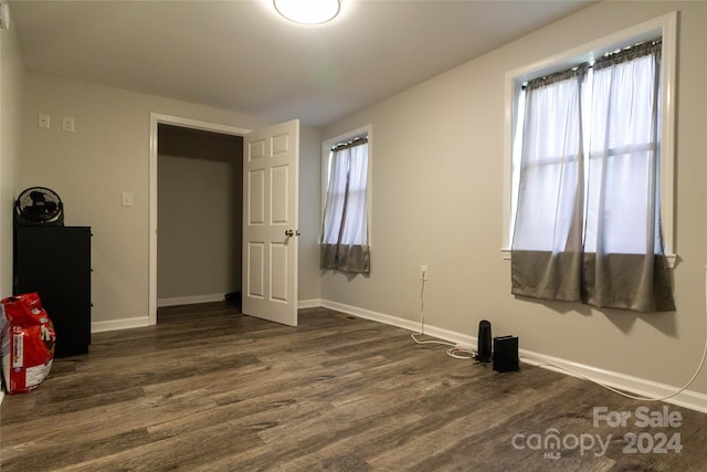 unfurnished bedroom featuring dark wood-type flooring and multiple windows