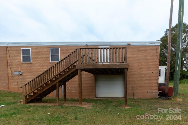 back of property with a yard and a deck