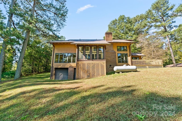 rear view of house featuring a yard and a sunroom