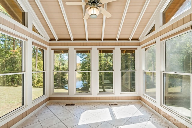 unfurnished sunroom with lofted ceiling with beams, ceiling fan, wooden ceiling, and plenty of natural light