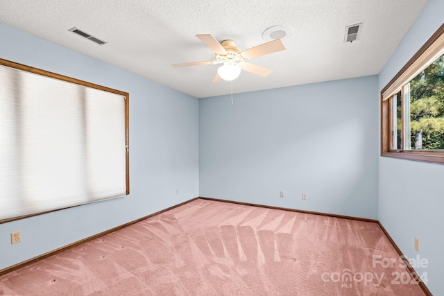 carpeted spare room with a textured ceiling and ceiling fan