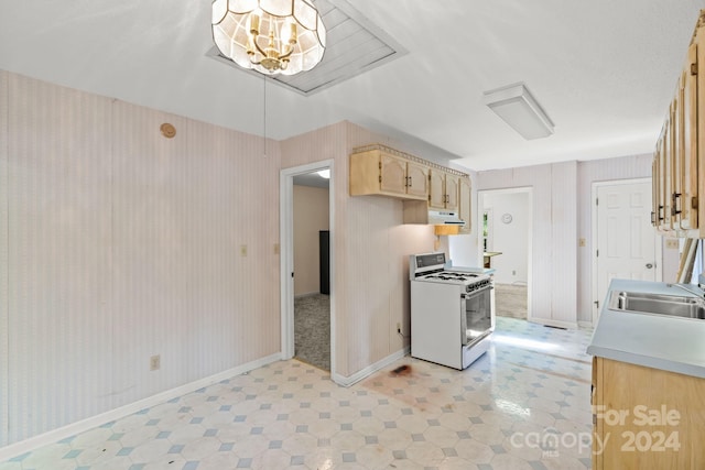 kitchen with sink, light brown cabinets, and white gas stove