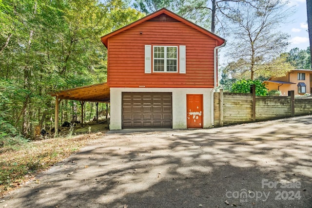 view of side of property with a garage and a carport