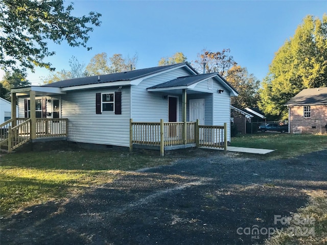 view of front of house with a front yard and a wooden deck