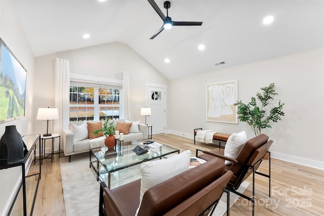 living room featuring light hardwood / wood-style floors, vaulted ceiling, and ceiling fan