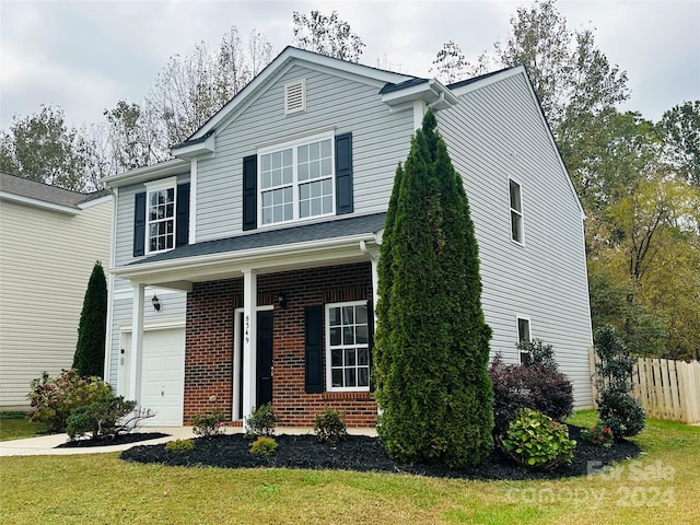 view of front property featuring a garage and a front lawn