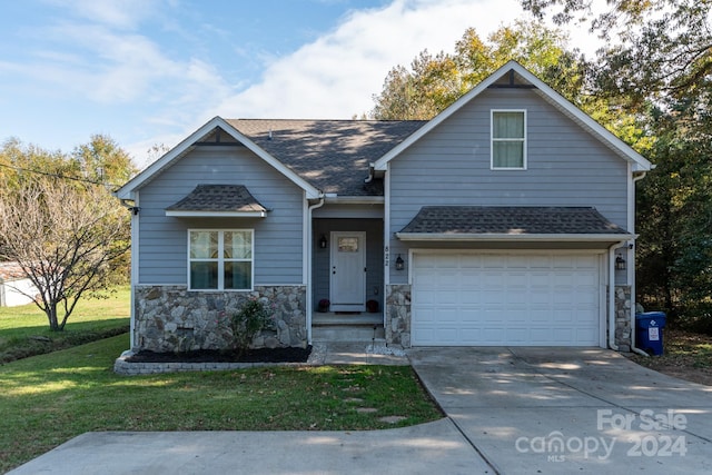 view of front of home featuring a front yard and a garage