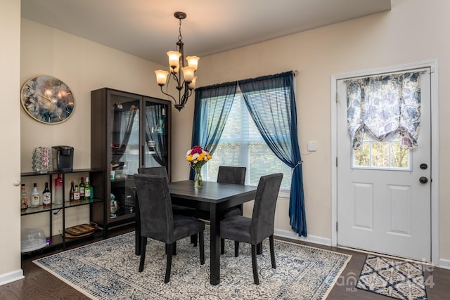 dining area with a healthy amount of sunlight, dark hardwood / wood-style flooring, and a chandelier