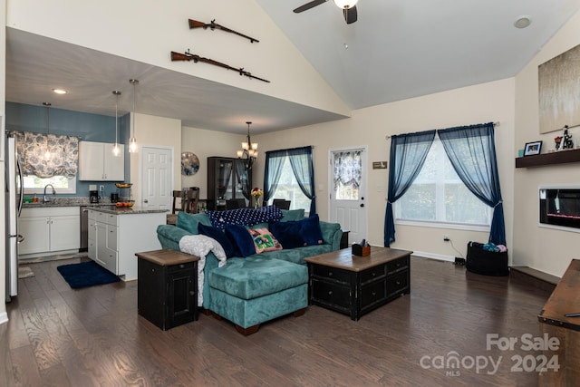 living room with high vaulted ceiling, ceiling fan with notable chandelier, and dark hardwood / wood-style flooring