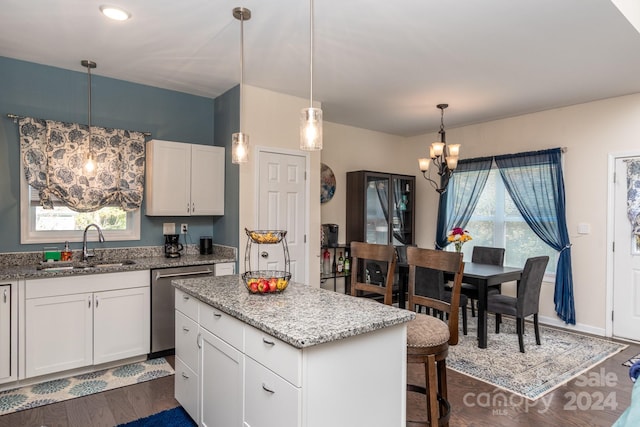 kitchen featuring dark hardwood / wood-style flooring, a kitchen island, white cabinetry, stainless steel dishwasher, and decorative light fixtures